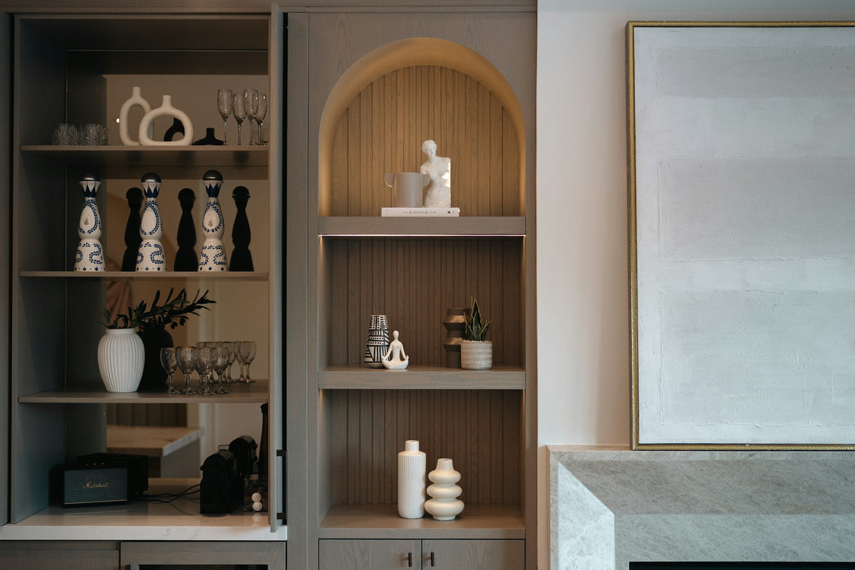 Decorative objects and ceramics arranged on warm neutral shelving