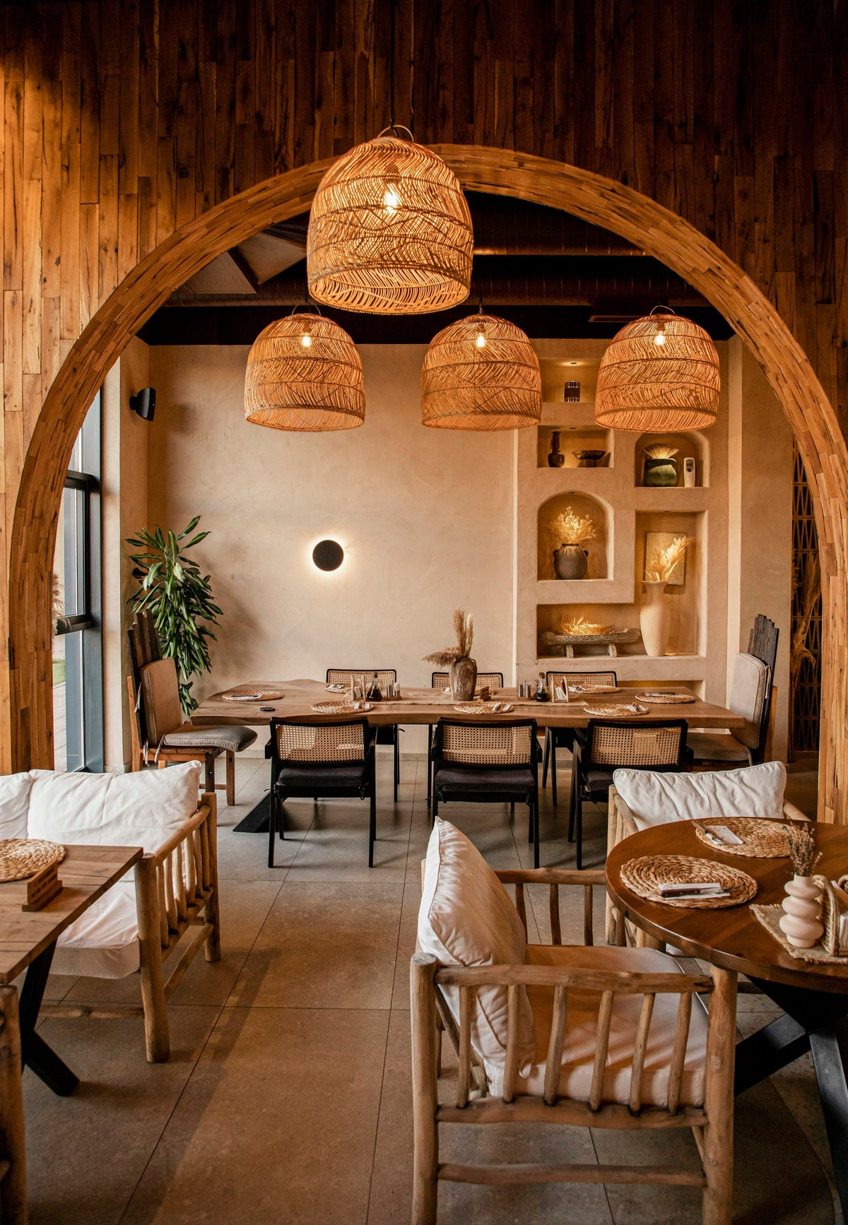 Warm woven pendant lights above a dining area