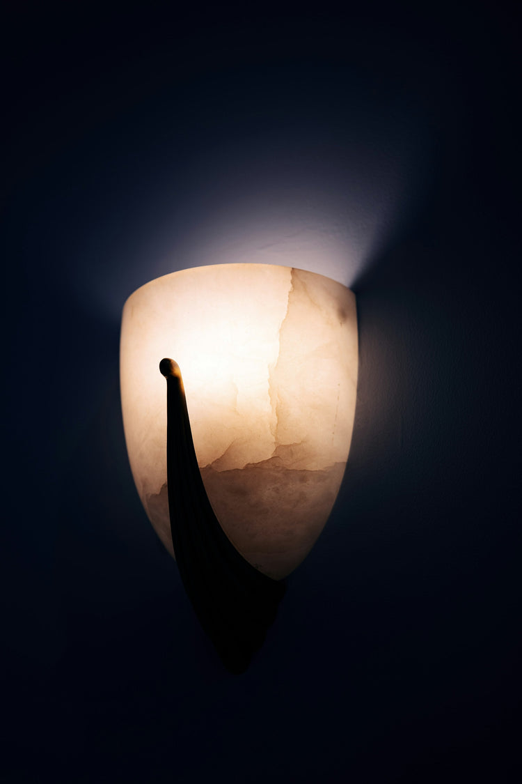 Sculptural wall light glowing against a dark wall