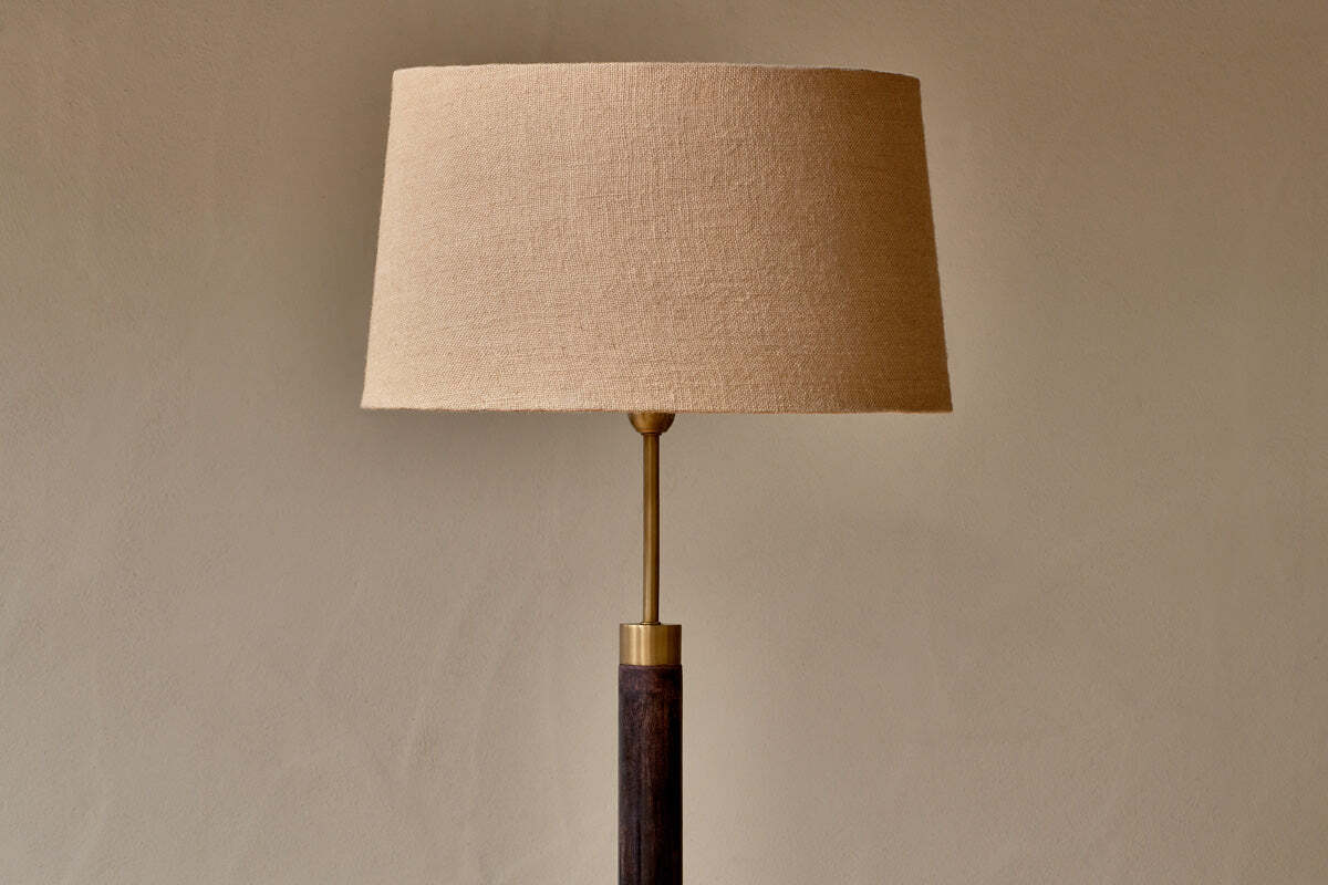 Detail of dark mango wood and antique brass floor lamp