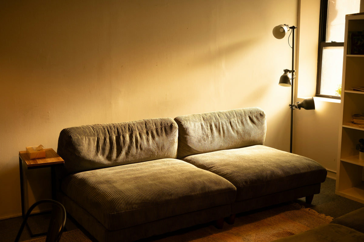 Warm living room with a floor lamp casting soft light across a sofa