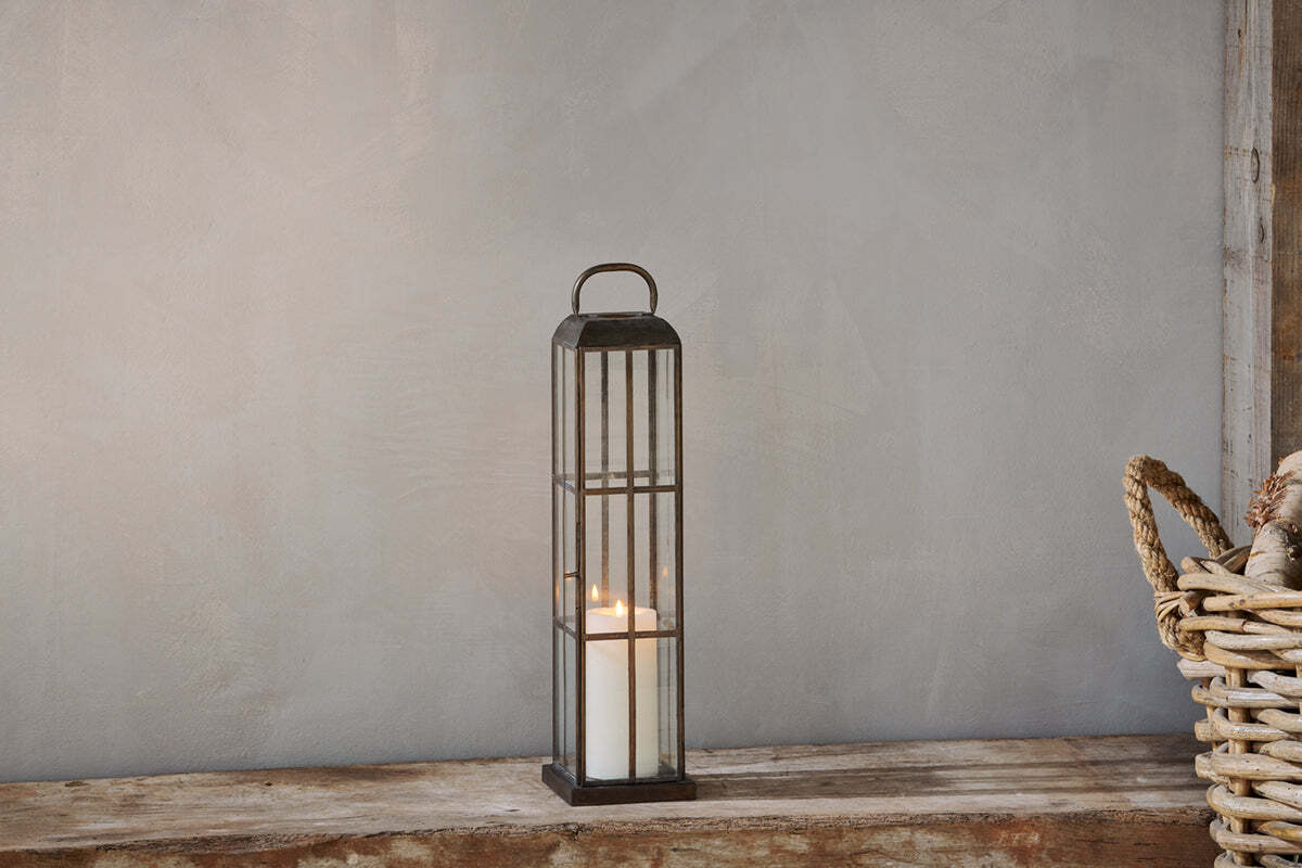 Antique brass lantern with glass panels in a styled interior
